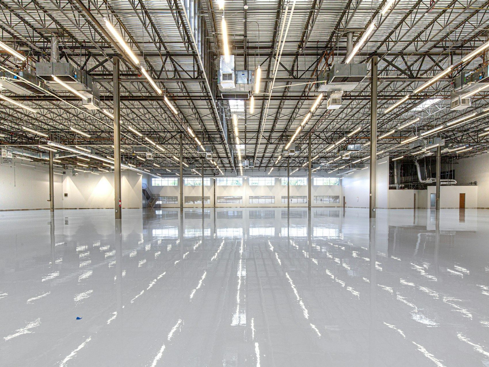 Highly reflective warehouse floor with overhead lighting